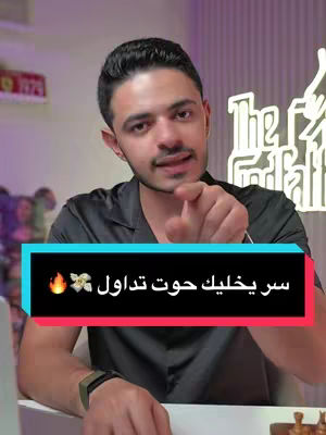 A man in a black shirt points towards the viewer, with a text overlay in a colored box displaying text.