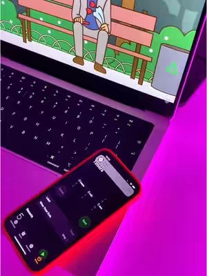 The image shows a laptop with a cartoon scene on its screen, an open smartphone with an app interface on the screen, displaying colorful interface, likely a timer app. The scene is set on a reflective surface, likely a colorful table, and it bathed in a pinkish purple light.