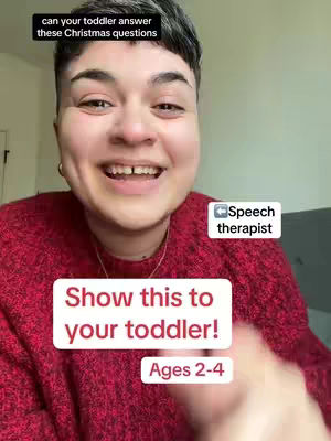 A smiling individual with short, dark hair, wearing a red sweater, looks directly at the camera. Text overlays include a question about toddlers and Christmas, and instructions to show the content to toddlers aged 2-4.