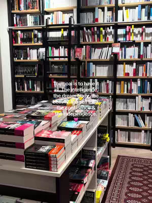 A shot of a bookstore interior with many bookshelves filled with books. A table in front of the shelves displays a variety of books and magazines. Overlayed text provides motivational messaging.
