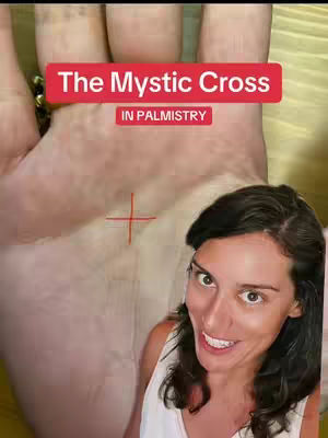 The cover image shows a fair-skinned woman smiling, with dark hair and a white top. She's positioned in the lower right. In the background is a close-up of a human hand, with a red rectangle containing the text 'The Mystic Cross' and 'IN PALMISTRY'. A red crosshair marks the area on the hand.