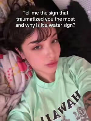 The cover image shows a young woman lying in bed, gazing at the camera. She is wearing a light green t-shirt with a partially visible graphic, and her face is centrally positioned. The background appears to be a bed, with a patterned blanket and dark pillows. Overlayed text is visible near the top. The lighting is soft and natural.