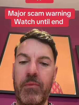 A man with a concerned facial expression is centered, with text overlays indicating a warning. Behind him hangs a piece of framed art, and the wall is a deep purple.