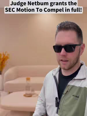 A man wearing sunglasses stands in front of a light-colored background, appearing to be in a living room setting. He is the central focus, with text overlaid at the top.
