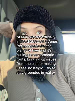 A woman in a car, wearing a black knit hat and a neutral-colored sweater, with text overlaid on the image about Venus retrograde.