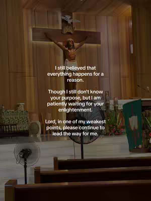 The image shows the interior of a church or religious building, with a wooden cross and a statue of Jesus on it. There are pews in front, a fan sits in the middle. The text overlay appears to be a message on the screen.