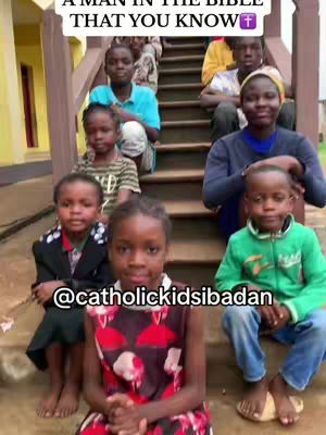 A group of children and adults are sitting on steps. The image is well lit. The group appears to be outside.