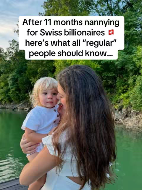 A woman holding a young child, with a lake and trees in the background. Text overlay indicates a nanny in Switzerland. The woman is wearing a white dress and the child is wearing a white shirt.
