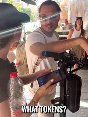 The image shows a man interacting with two women, one holding a phone displaying an app interface. A sign with blurred text is in the background. The primary colors are natural tones, making the scene appear casual, possibly outdoors or in a brightly lit location. A hook text is added to the bottom.