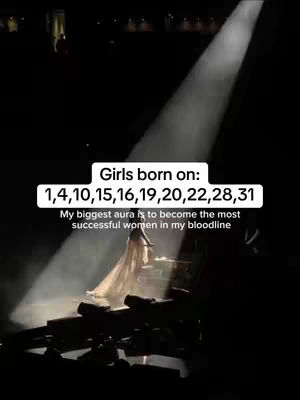 A woman in a flowing gown stands on a stage under a spotlight against a dark background. Text overlays indicate a numerology concept.