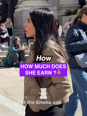 A woman in a beige jacket stands on a city street with a purple overlay containing text. Other people are visible in the background, including some sitting on steps. The woman is in profile, looking to her left.