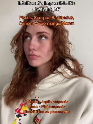A young woman with long, wavy reddish-brown hair and fair skin gazes thoughtfully upward. She's wearing a white hoodie, and text overlays list astrological signs and phrases about intuition. The background is a light neutral tone.