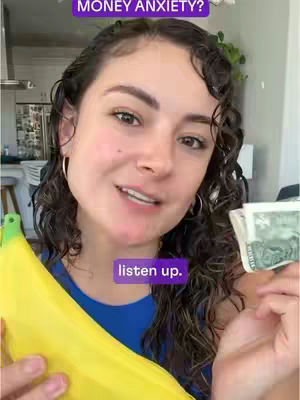 A medium shot features a young woman holding a wad of US dollar bills with a green banana in the foreground, with text overlays. The woman is smiling and looking towards the camera. The background is blurred interior of a home. There is text on the image that says MONEY ANXIETY?