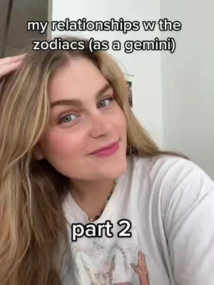 A young woman with long blonde hair smiles at the camera. Above her head is the text overlay "my relationships w the zodiacs (as a gemini)". Below her the overlaid text reads "part 2". She is wearing a white t-shirt.
