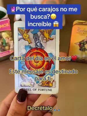 The cover image features a hand holding a tarot card, 'Wheel of Fortune.' Above the card is a bubble with text. Below, text overlays declare the card's message is intended for the viewer, next to a heart emoji. The background includes blurred items and colors, adding to the mystical theme.