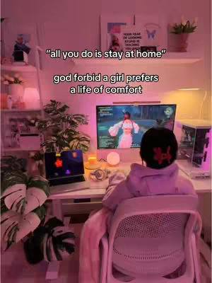 A woman sits at a desk, facing away from the camera, playing a video game on a large monitor. Text overlays on the image express the introvert theme of the video. The room is brightly lit with a pinkish hue, and various decorative items are visible on shelves.