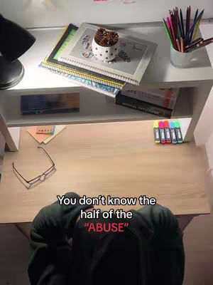 A top-down shot shows a desk with a computer lamp on the top left, two shelves below, and a person in a black hoodie filling the foreground in an unseen setting. On the top shelf are books and a pen holder, and the top shelf has books, glasses and multiple colored erasable markers. The hook text is centered at the bottom of the image.