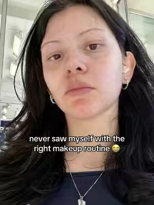 The cover image shows a close-up selfie of a woman with long, dark hair. She has a neutral facial expression with a slightly downturned mouth.. Text overlayed on the image says,
"never saw myself with the right makeup routine" .