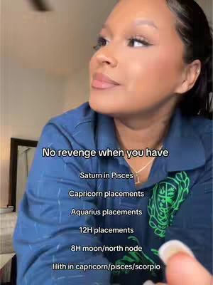 A young woman poses on camera from a slight angle, looking off to the side with a soft expression. She has her hair pulled back, and is wearing a blue button-down shirt. Text overlays are present on the image, suggesting astrology-related content.