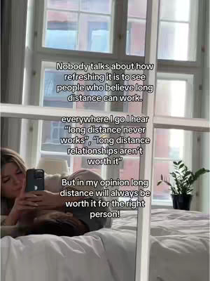A woman is filming herself with a phone in a bedroom setting.  The room has large windows, a bed, and a plant.  Text overlays the image in white.
