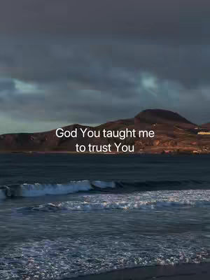The cover image shows a scenic view of the ocean and dark, cloudy sky. The water in the foreground has visible waves. A mountain range is visible in the background. Text overlayed at the top of the image reads "God You taught me to trust You" in white font.
