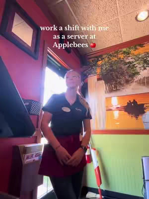 A woman in a server uniform stands in a restaurant, with text overlayed. The background has a window, art and an Applebees logo in the corner.