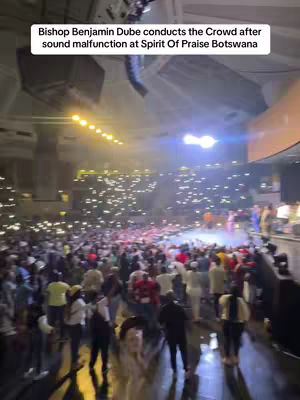 The cover image shows a crowded indoor setting, likely a concert or event. The space is filled with people, most of whom are holding up illuminated phones. A stage is visible in the background, and the lighting highlights the scale and energy of the event.