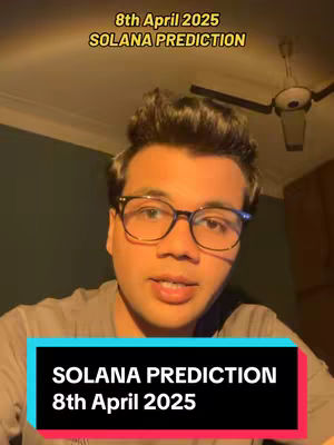 A man with short dark hair and glasses is centered in the frame. He's looking directly at the camera and speaking. Above him, text in a golden yellow color reads '8th April 2025' and 'SOLANA PREDICTION'. A lower section features a black rectangular overlay with white text repeating 'SOLANA PREDICTION' and '8th April 2025'. The background is dimly lit with a ceiling fan visible.