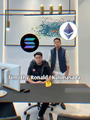 The image shows two men in what appears to be an office setting. The man on the left is wearing glasses and a black jacket and is seated. The man on the right is standing and wearing a blue vest over a white shirt. There are two cryptocurrency logos in the background: the Solana logo and the Ethereum logo. The text overlay at the bottom says Timothy Ronald / Kalimasada.