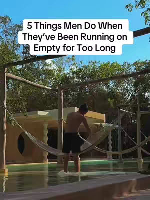 The image shows a man standing in waist-deep water, looking down. The setting appears to be a pool area with lush greenery and a wooden structure overhead. Text overlayed at the top of the image reads: "5 Things Men Do When They’ve Been Running on Empty for Too Long".