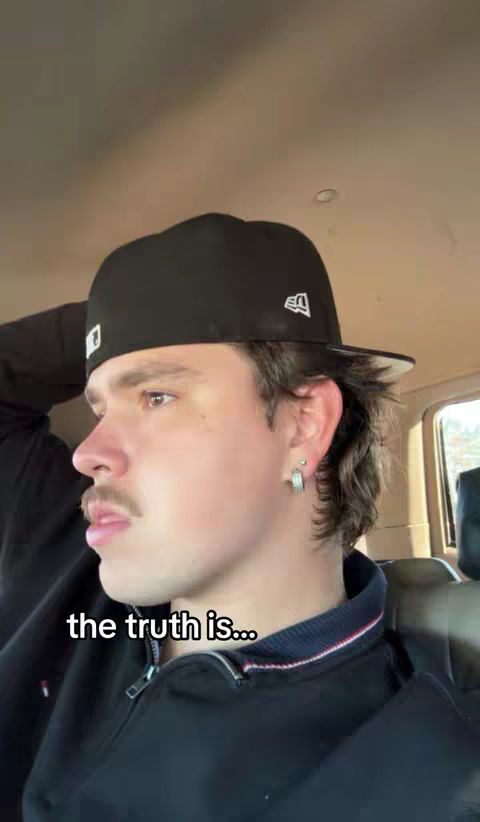 A man in a black hat and jacket is shown in profile, looking to the left. Text overlayed on the image says the truth is...