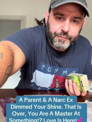 A man with a beard and a baseball cap is holding a deck of cards. He is wearing a dark blue Tommy Hilfiger t-shirt. A text overlay at the bottom reads, 'A Parent & A Narc Ex Dimmed Your Shine. That Is Over, You Are A Master At Something!? Love Is Here! 💕'