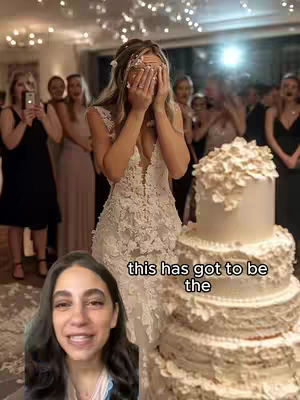 A vertical cover image shows a woman in a white wedding dress, covering her face with her hands in front of a wedding cake. A second shot of a woman smiling is in the bottom left of the frame. There are other people in the background and the image is lit with warm, indoor lighting.