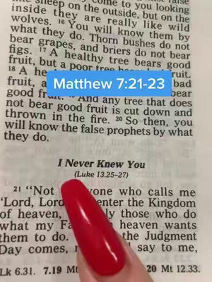 A hand with red nail polish points at the text "I Never Knew You" from a Bible displayed on a page. A light blue rectangle at the top of the page shows text written as "Matthew 7:21-23". The image is a close up with a focus on the text and the nail.