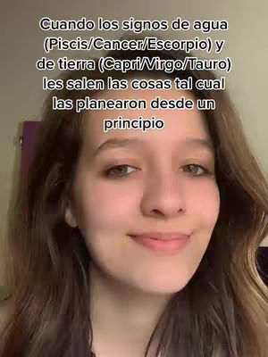 A young woman with light brown hair and a soft complexion is centered in the frame, shot from the chest up. She appears to be in a home setting, as suggested by the solid background in muted tones. The text overlay is stacked, white, and capitalised is on top which discusses astrology and zodiac signs.
