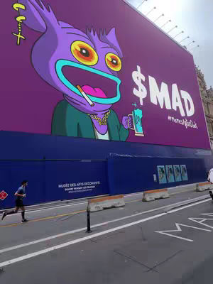 The image shows a large purple billboard featuring a cartoon character smoking a cigarette and holding a beer. The background of the image is a large purple building and a street corner. In the bottom left corner, there is a person running on the street.
