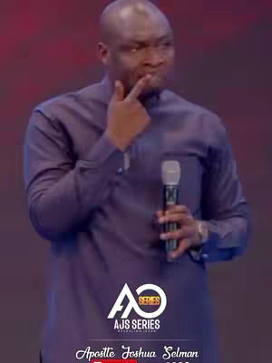 A man with short dark hair, wearing a purple long-sleeved shirt, is captured from the torso up on a blurred background. The man is holding a microphone in his right hand and has his left index finger touching his lips, appearing to be in thought. A logo is visible at the bottom, indicating a religious service.