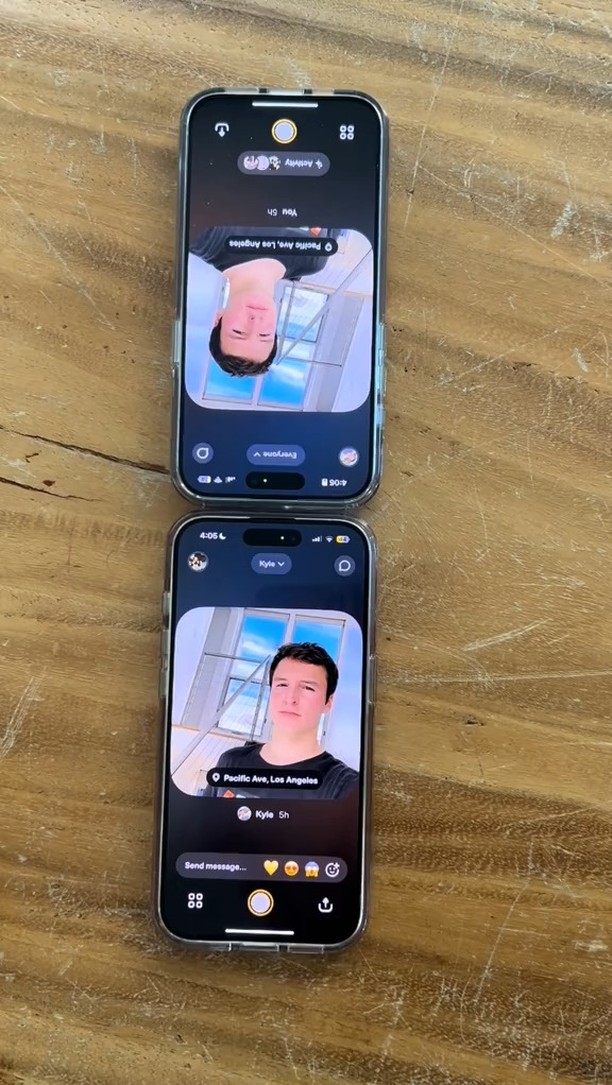 Two phones are displayed side-by-side, both showing a selfie of a young man with the Locket app interface. The phones are on a light brown wooden surface. The app interface includes text overlays, displaying profile information and the location of the subject. The overall composition is well-lit and showcases the app's functionality.