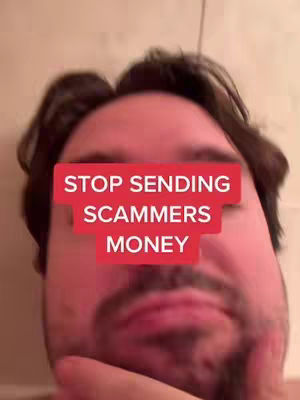 A close-up shot of a man's face. A red rectangular text overlay covers the center of his face, obscuring his eyes and nose, with the words 'STOP SENDING SCAMMERS MONEY'. The man is looking down with a partially visible beard.