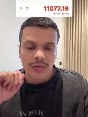 The cover image shows a man in what appears to be an indoor setting, likely appearing to be recording a video. Behind him is a light-colored wall and horizontal blinds. The man has short dark hair and a mustache, wearing a dark t-shirt and making a hand gesture. The top of the screen displays market data for the Saudi Stock market, with figures in red.