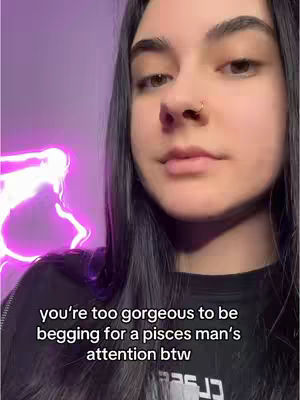 A selfie-style video cover image with a young woman centered in the frame. She has dark hair, dark eyes and a nose ring. The background is a blurred purple with a glowing neon outline of a shape to the left. Text overlayed at the bottom says, "you're too gorgeous to be begging for a pisces man's attention btw".