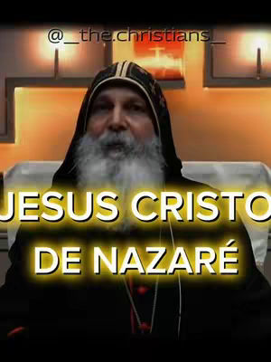 A close-up shot of a man with a white beard and dark hooded attire. Bold, yellow-outlined text overlays the image, with the text "JESUS CRISTO DE NAZARÉ". The background shows a soft, blurred interior.