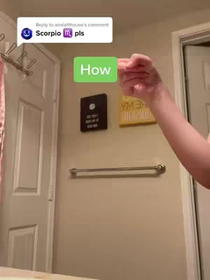 A hand is pointing at a green rectangle with the word "How" on it in a bathroom setting.