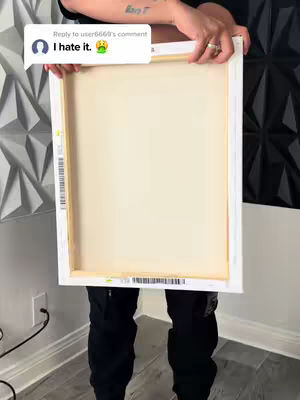 The cover image shows a person holding a canvas in front of their body. The canvas is white and has wooden supports. The person is wearing black pants and a black top. A speech bubble with text is overlaid on the image and a small tattoo is visible on the arm.