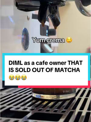 The image shows the top part of a coffee machine with crema dripping, a text overlay that says “Yum crema” an emoji is displayed. In the background a text overlay is displayed in a white and green rectangular box, the text says "DIML as a cafe owner THAT IS SOLD OUT OF MATCHA" with 3 crying emojis.