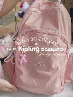 The cover image shows a pink Kipling backpack against a soft, slightly blurred background. Text overlays include "back to school" and the brand name Kipling as the prominent focus. Various colorful accessories such as a Hello Kitty plushie and a pink charm are attached to the backpack.
