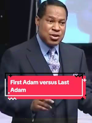A man in a suit is speaking into a microphone. A red bar containing white text overlays the bottom portion of the image. The background is blurred and appears to be a stage or studio setting.