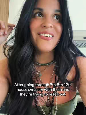 A woman with dark hair is centered in the frame, looking up and to the side with a slight smile. She has multiple necklaces on. White text is placed at the bottom of the image.