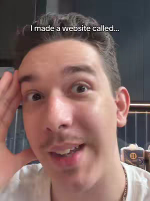The cover image is a selfie of a young man with dark hair and a small mustache. He is looking towards the camera, expression slightly surprised. Text overlayed at the top says 'I made a website called...'. The background is slightly out of focus, suggesting an indoor setting. The man is wearing a white t-shirt and a necklace that has a chain. Light falls on the face from above, highlighting his features.