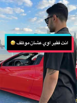 Image shows a man in sunglasses looking to the side with a red sports car in the foreground, set against a sky on top of a building. The background includes a modern looking city skyline. A text overlay in a turquoise box reads "You are very poor because you are an employee" in Arabic.